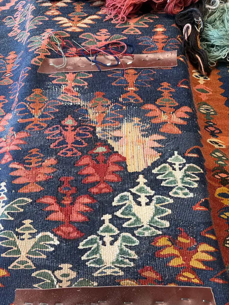 Kilim ancien en cours de restauration à la duite sur une zone de trame rompue