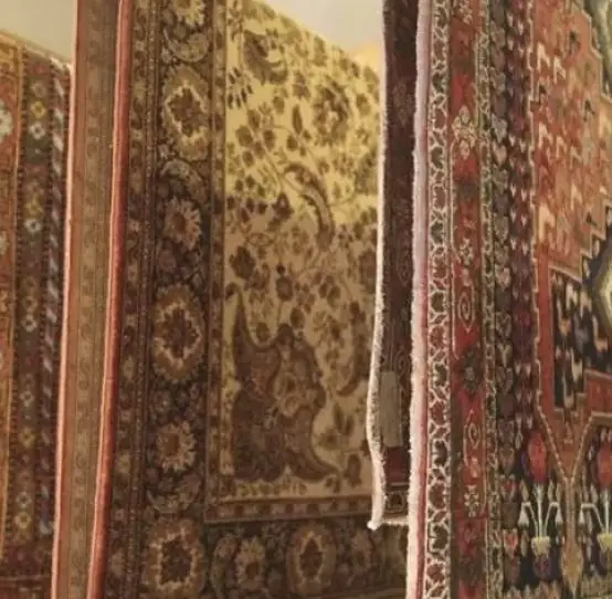 Tapis d'Orient anciens suspendus côte à côte dans le showroom de l'atelier