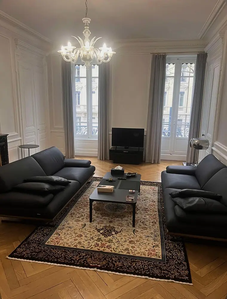 Tapis persan restauré posé sur un parquet en point de Hongrie dans un salon bourgeois